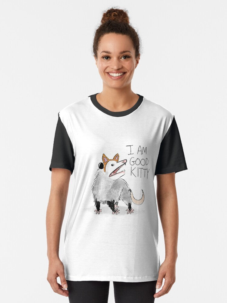 A graphic t-shirt with the text "I AM GOOD KITTY" and an opossum or possum design. - Women