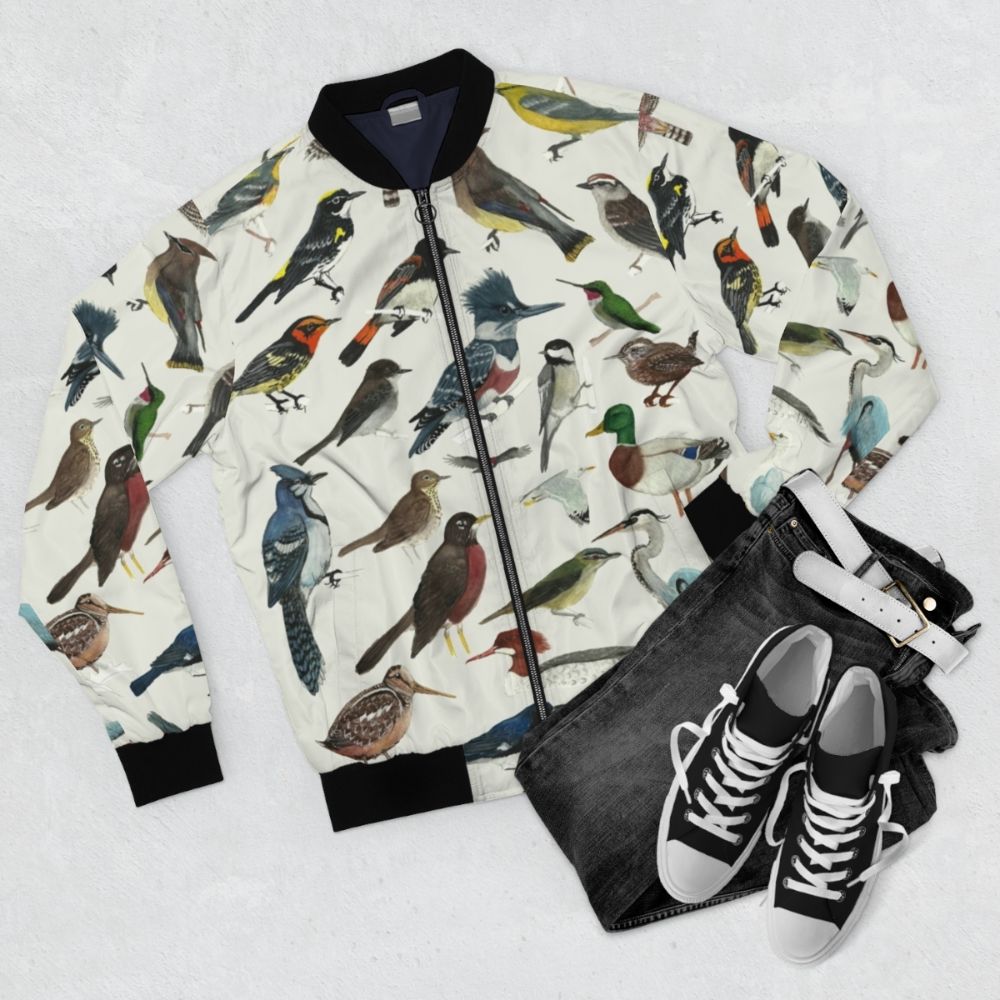 Stylish bomber jacket featuring illustrations of various bird species, including warblers, herons, hummingbirds, and more. - Flat lay