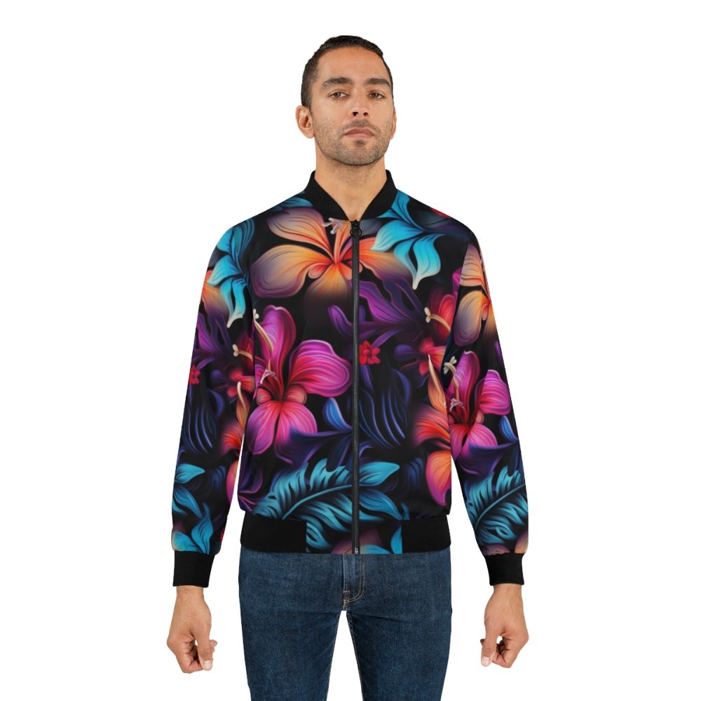 Model wearing a dark Hawaiian pattern bomber jacket with tropical flowers and bioluminescent designs - Lifestyle