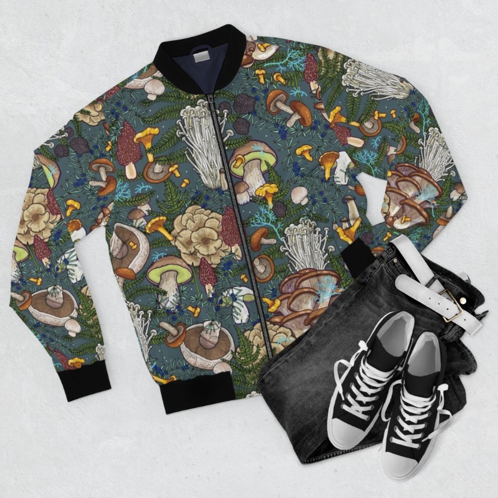 A bomber jacket featuring a pattern of various mushrooms and foliage in a forest setting. - Flat lay