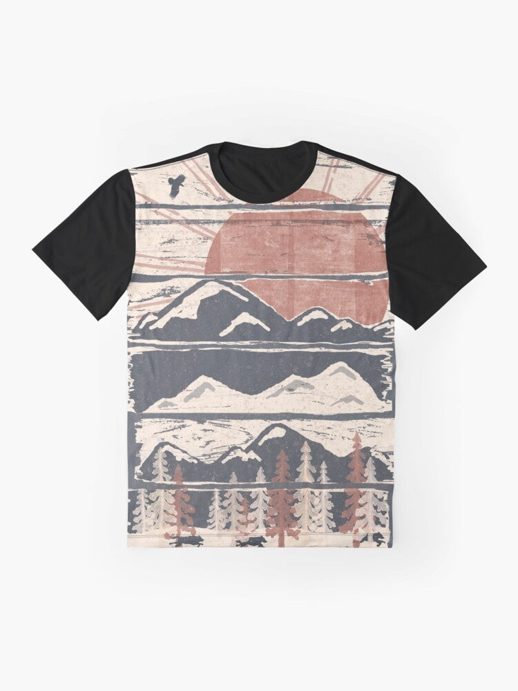 A graphic t-shirt featuring a winter landscape with wildlife such as wolves, hawks, and eagles. - Flat lay