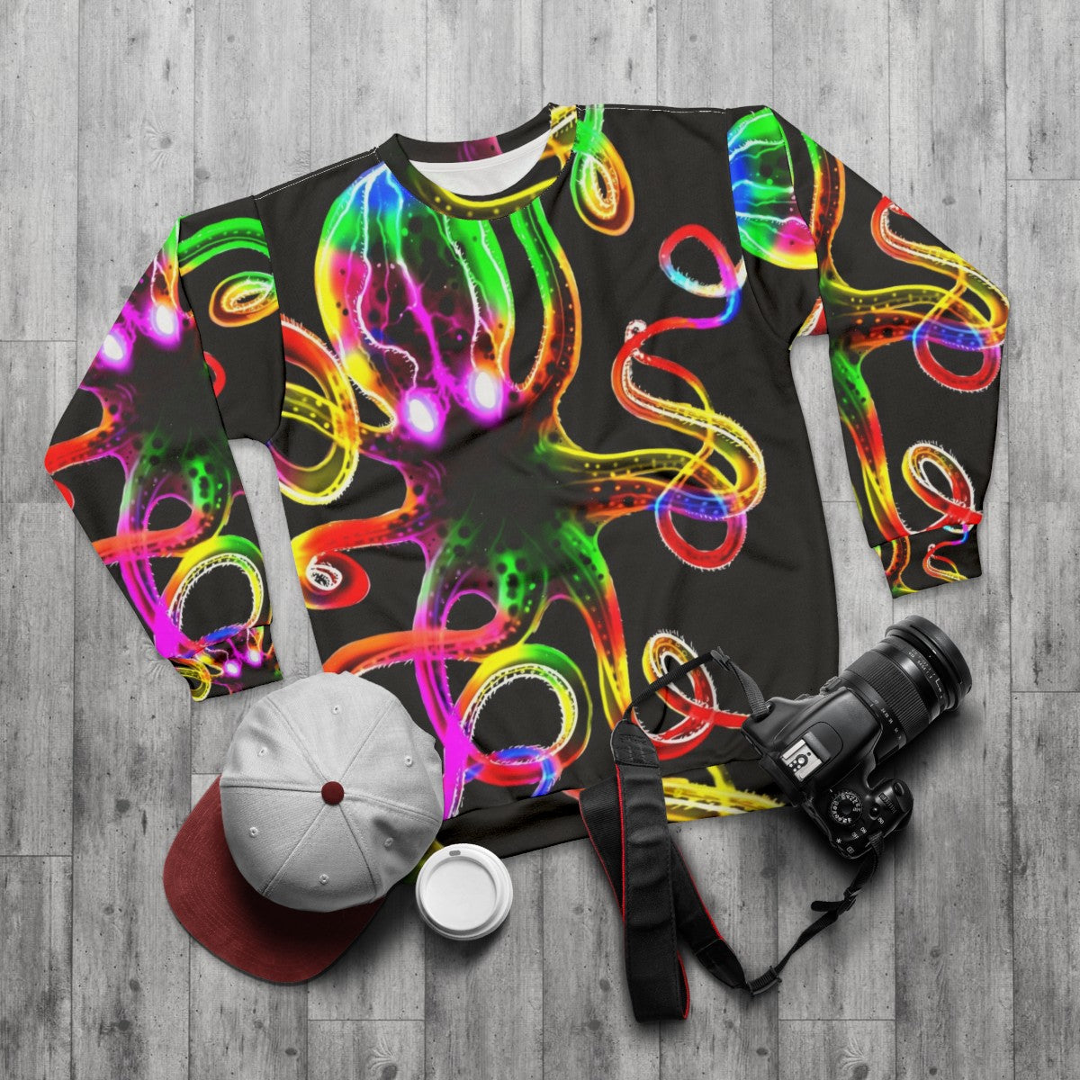 A vibrant rainbow octopus glowing in the dark on a sweatshirt - flat lay