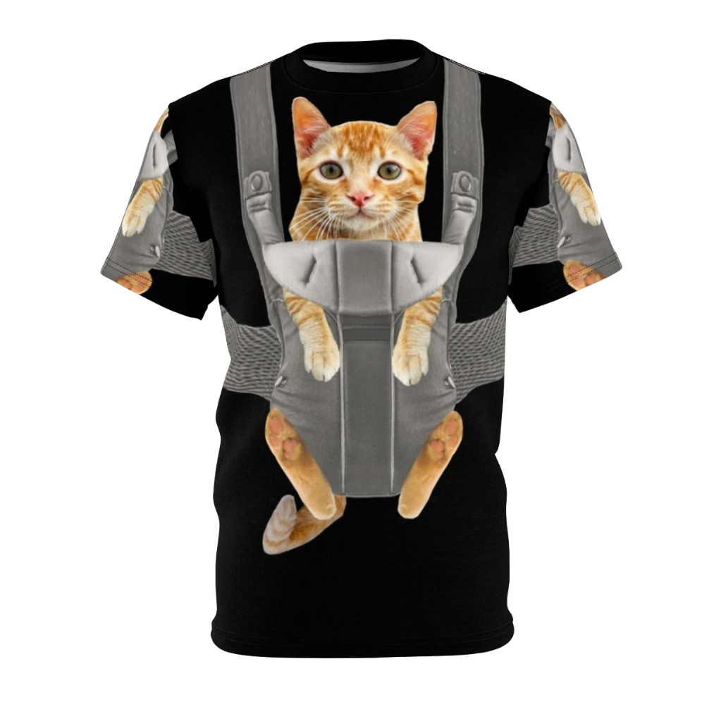 An adorable orange tabby cat named Monty sitting comfortably in a baby carrier on a t-shirt.