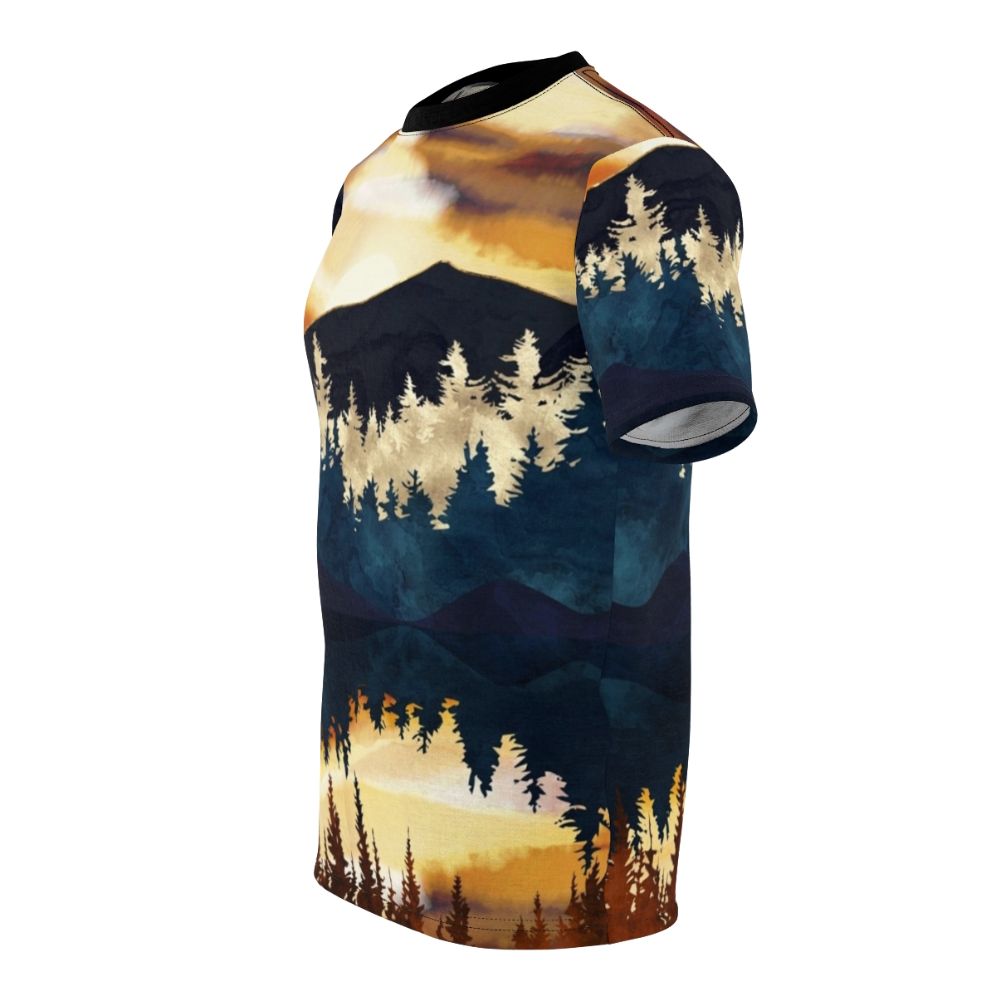 A t-shirt featuring a vibrant, watercolor-style landscape design with a beautiful fall sunset over a lake, surrounded by forests and mountains. - men left