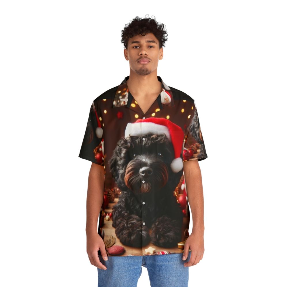 Black Cockapoo wearing a Santa hat on a Christmas Hawaiian Shirt - People Front