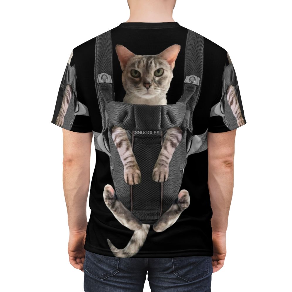 Adorable cat snuggled in a baby carrier on a gray t-shirt - men back