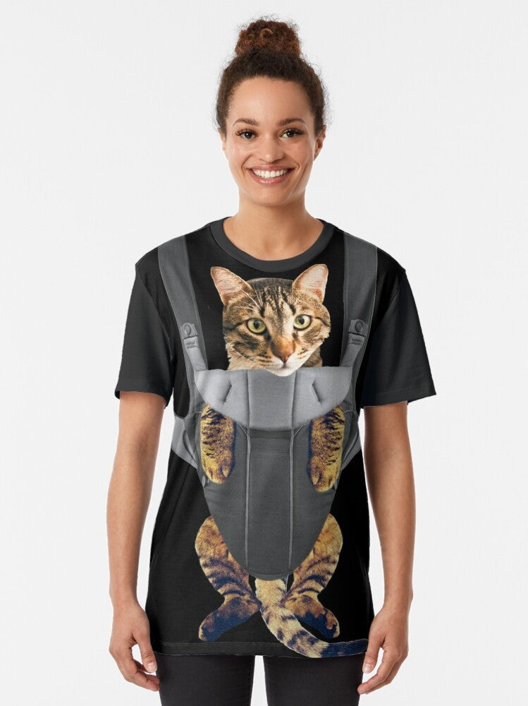 A funny graphic t-shirt design featuring a cat in a baby carrier. - Women