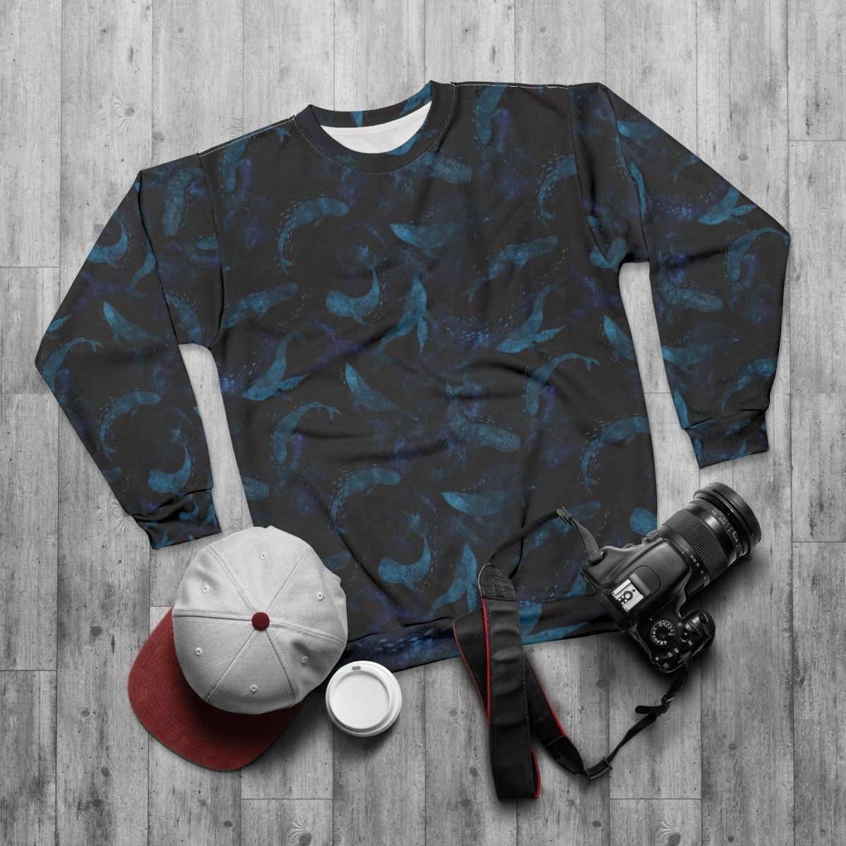 Indigo blue sweatshirt with a design of whales dancing underwater - flat lay