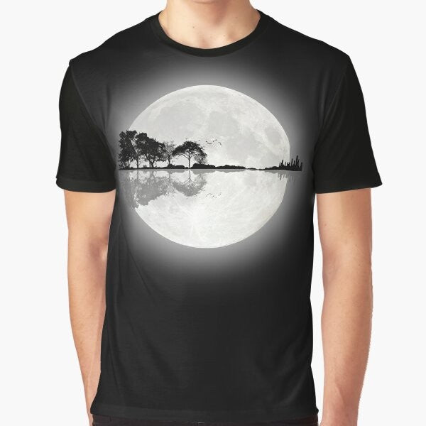 A minimalist t-shirt design featuring a silhouetted guitar against a nature landscape with a moon, stars, and water reflection.