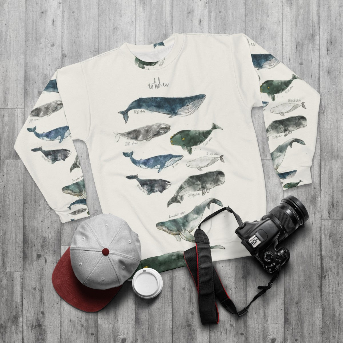 Watercolor whales sweatshirt featuring humpback and beluga whale designs - flat lay