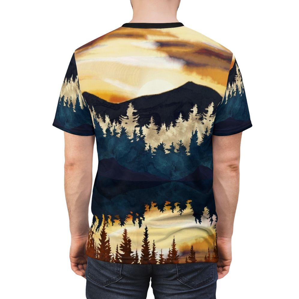 A t-shirt featuring a vibrant, watercolor-style landscape design with a beautiful fall sunset over a lake, surrounded by forests and mountains. - men back