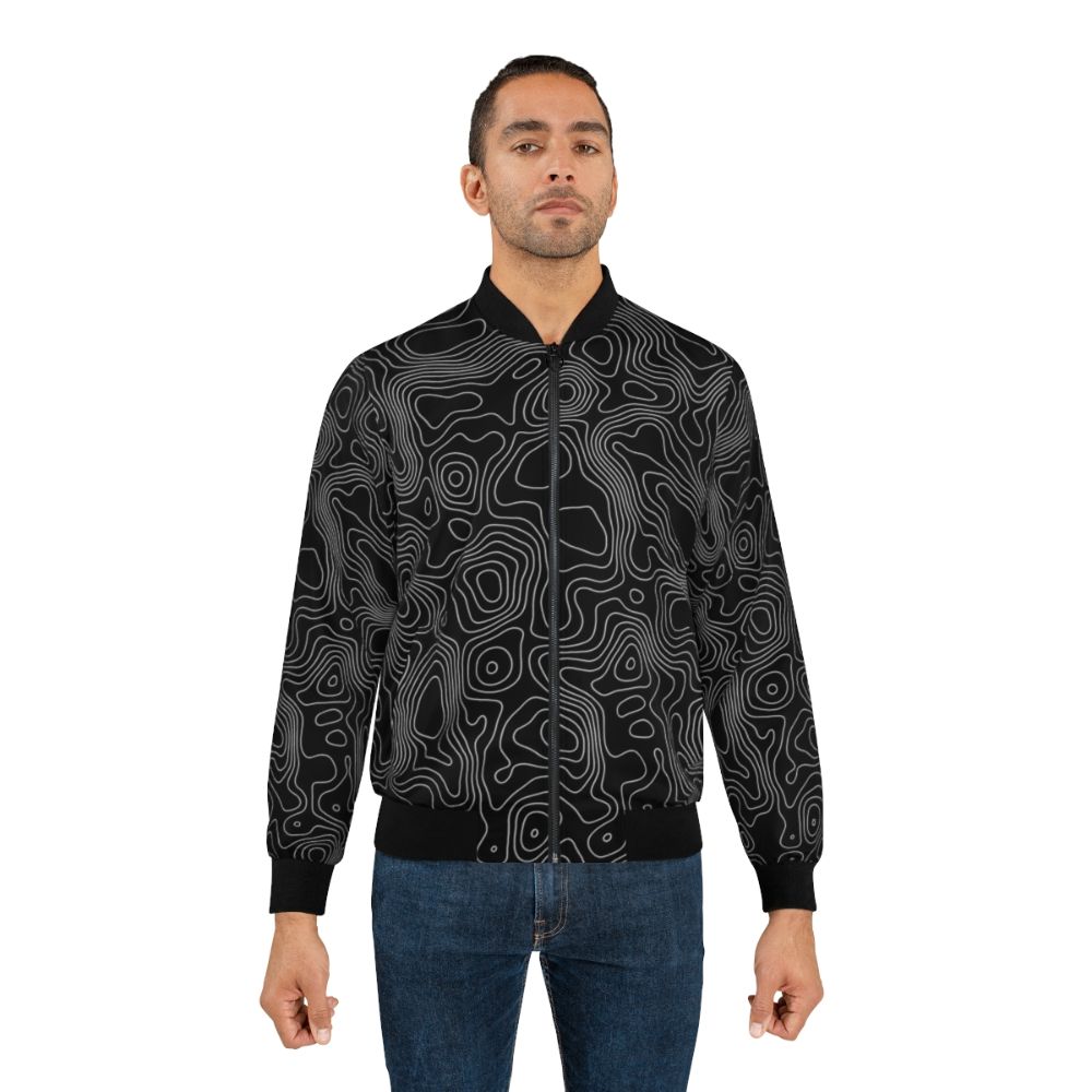 A minimalist bomber jacket featuring a topographic contour line abstract design in black and white. - Lifestyle