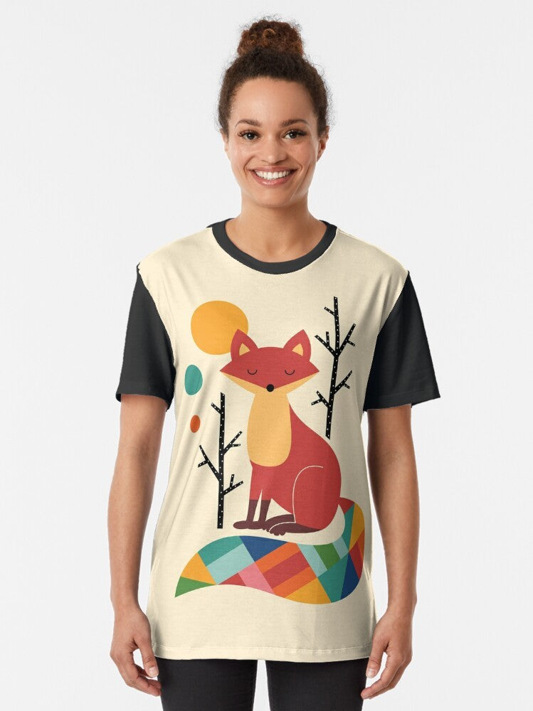 A colorful graphic t-shirt featuring a vibrant rainbow fox in a natural forest landscape. - Women