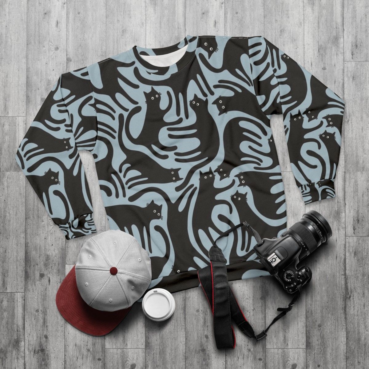 Blue sweatshirt with a modern black cat print design - flat lay