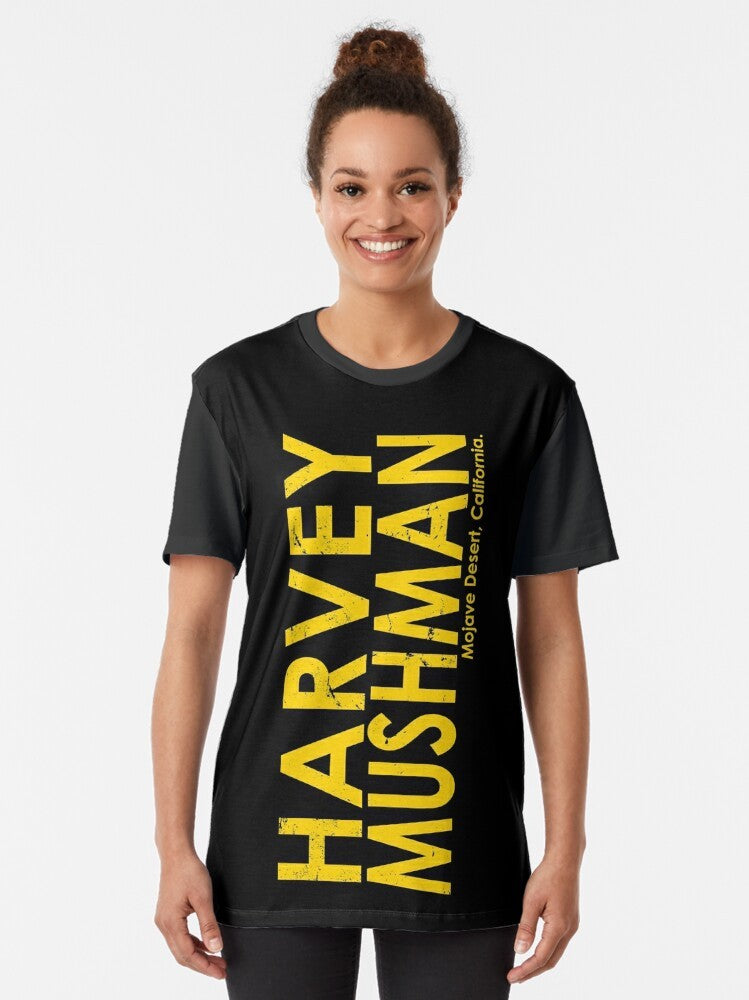 Vintage-style graphic t-shirt featuring the "Harvey Mushman" design, with a classic motorcycle and desert racing theme. - Women