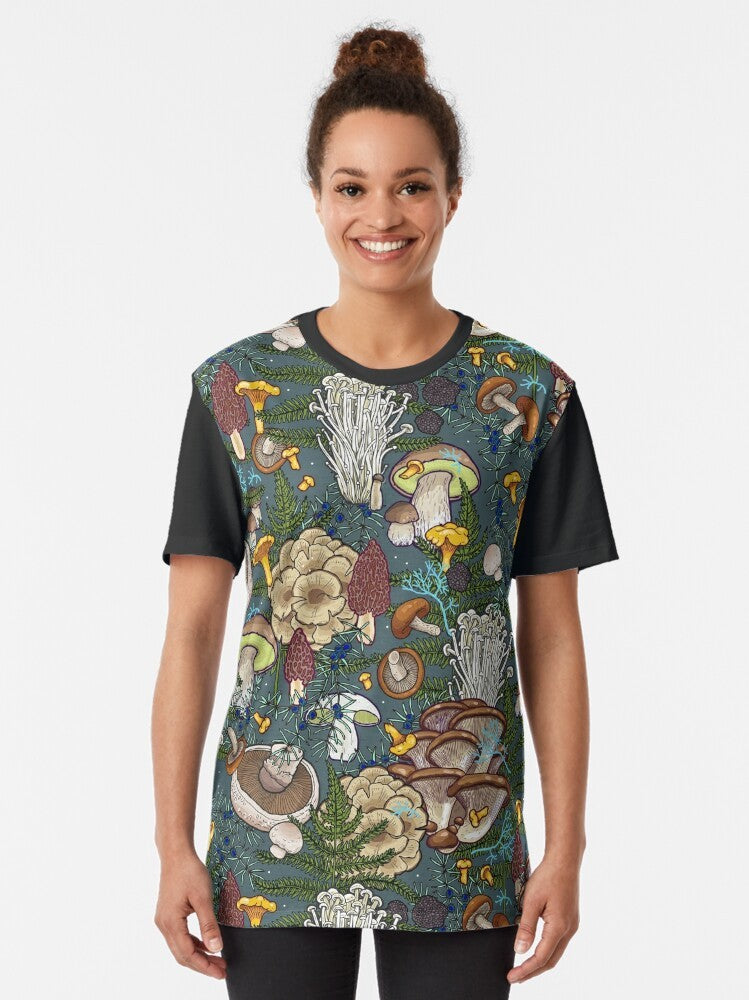 Graphic t-shirt featuring a pattern of various mushrooms in a forest setting, including chanterelle, portobello, bolete, oyster, truffle, and more. - Women