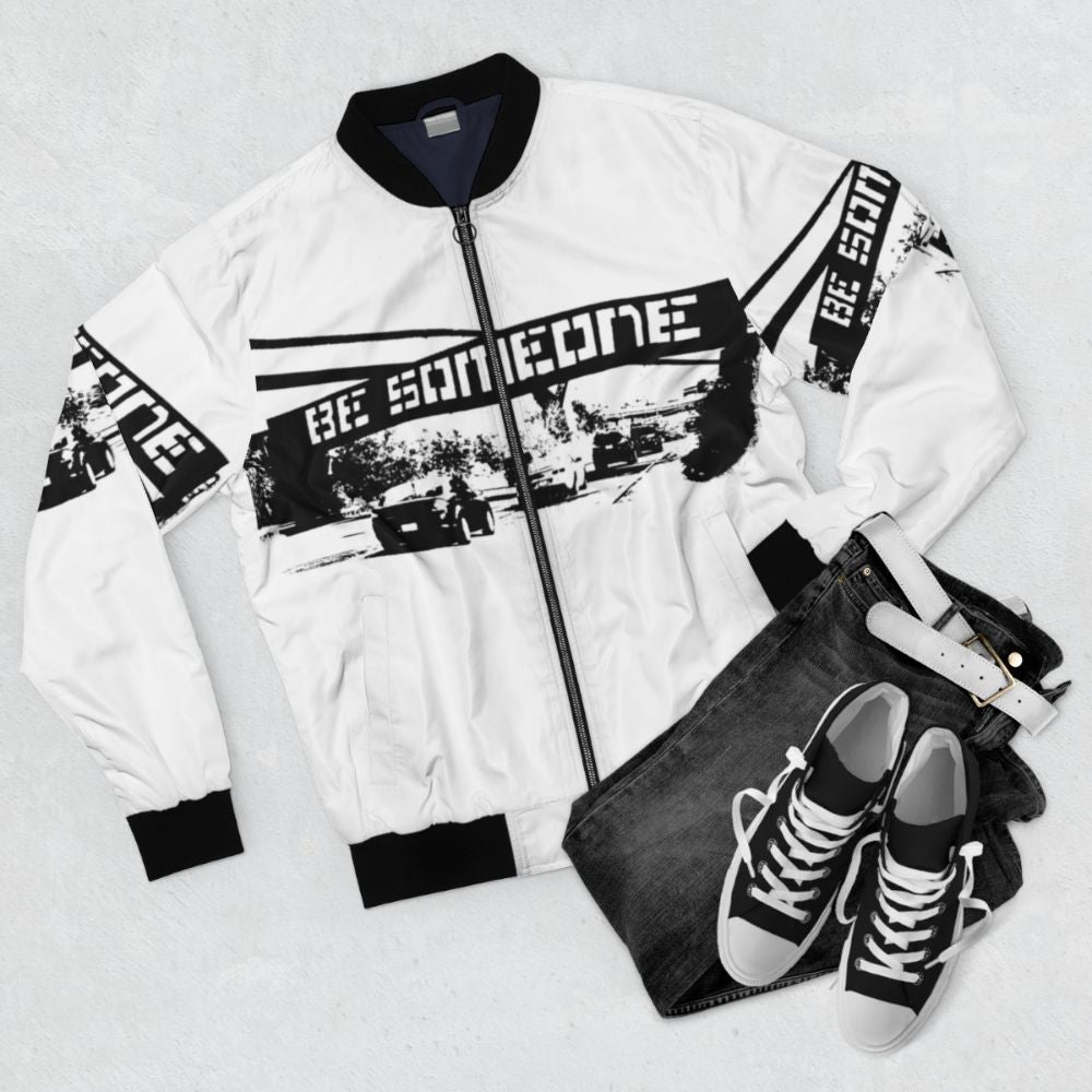 "Be Someone Houston Bomber Jacket featuring graffiti-inspired two-tone design and community-driven graphics" - Flat lay