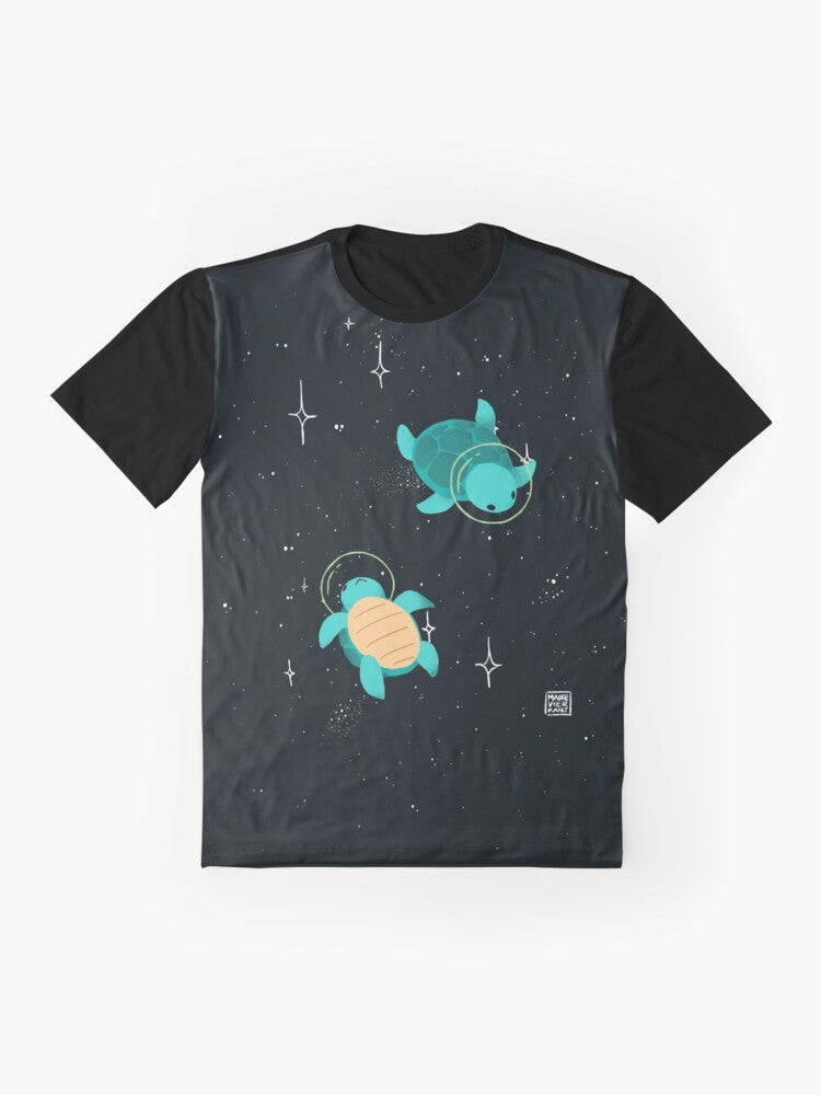 Adorable space turtle graphic design on a green t-shirt with stars and cosmic elements. - Flat lay