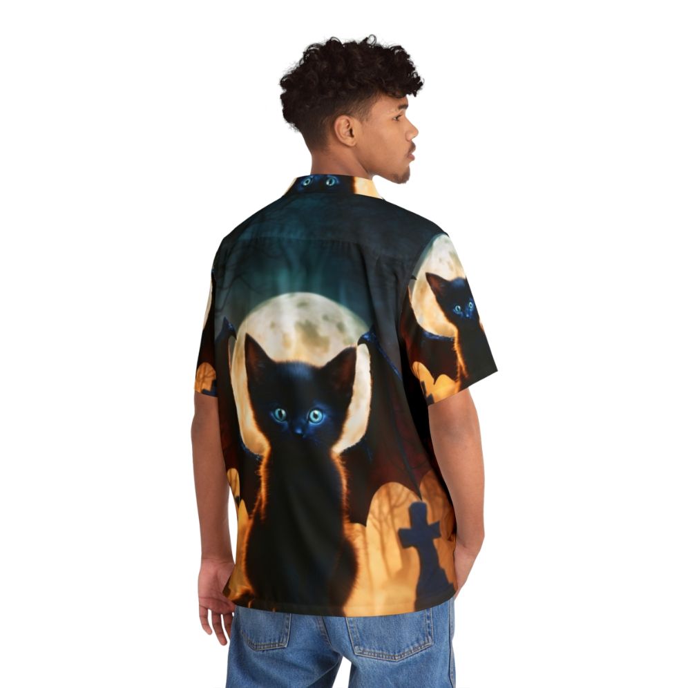 A black dragon kitten sitting in a graveyard on a colorful, digital fantasy Hawaiian shirt - People Back