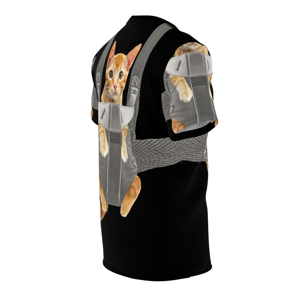 An adorable orange tabby cat named Monty sitting comfortably in a baby carrier on a t-shirt. - men right