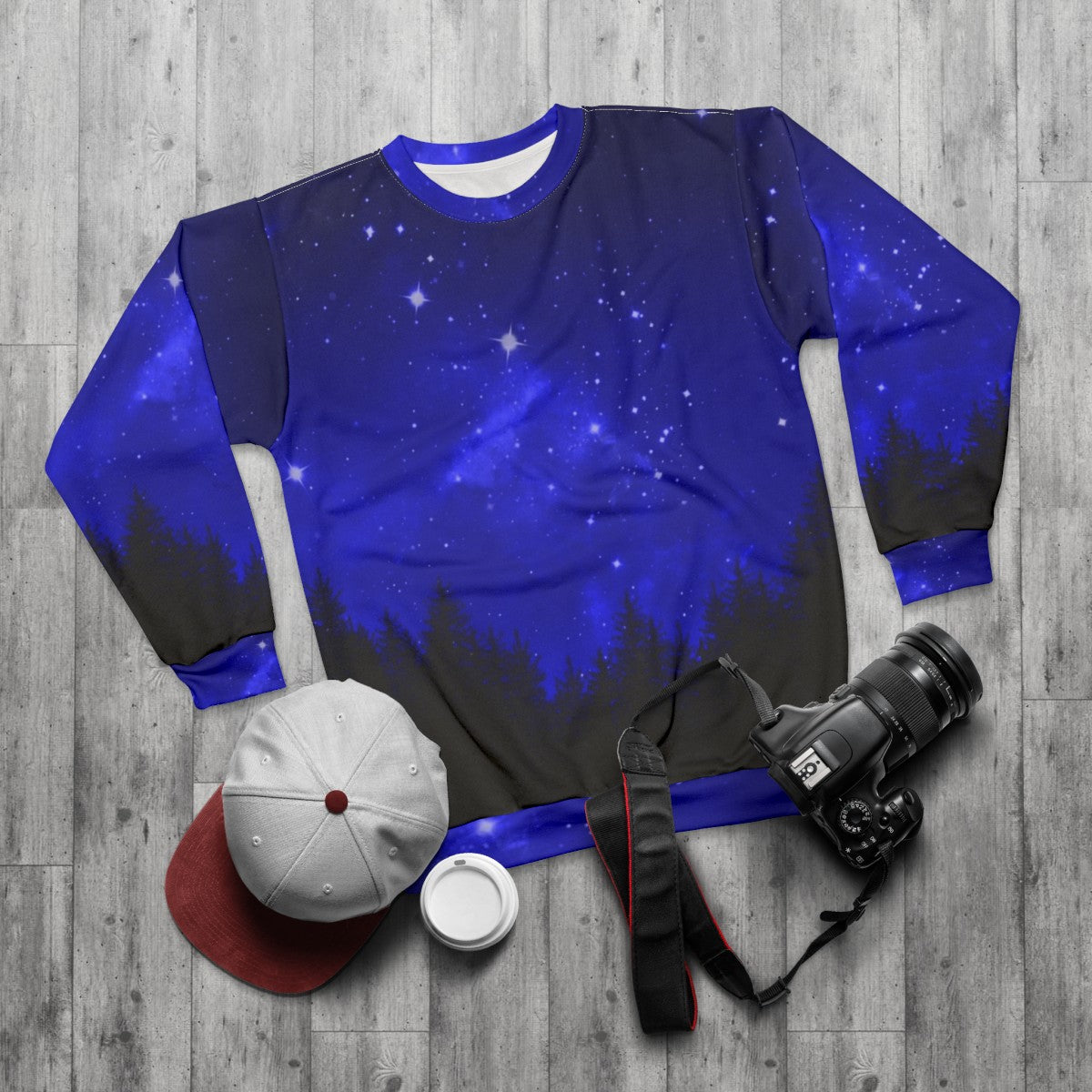 Blue galaxy forest night sky sweatshirt with trees and mountains - flat lay