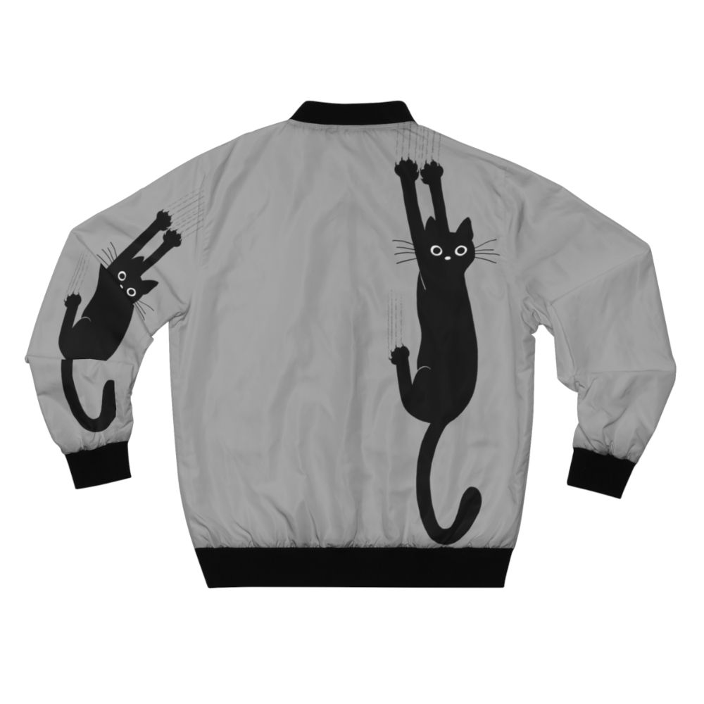 Black cat holding on to a bomber jacket with a playful, humorous expression - Back