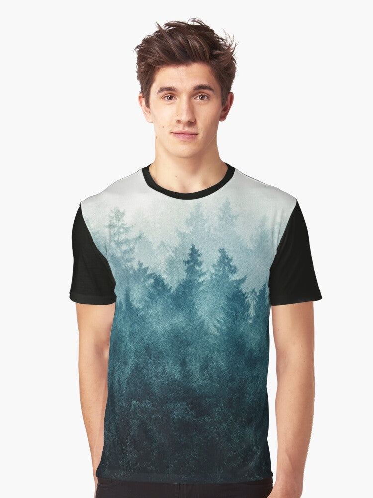 Graphic t-shirt design featuring a misty, foggy forest landscape with trees, mountains, and a blue-toned color palette - Men