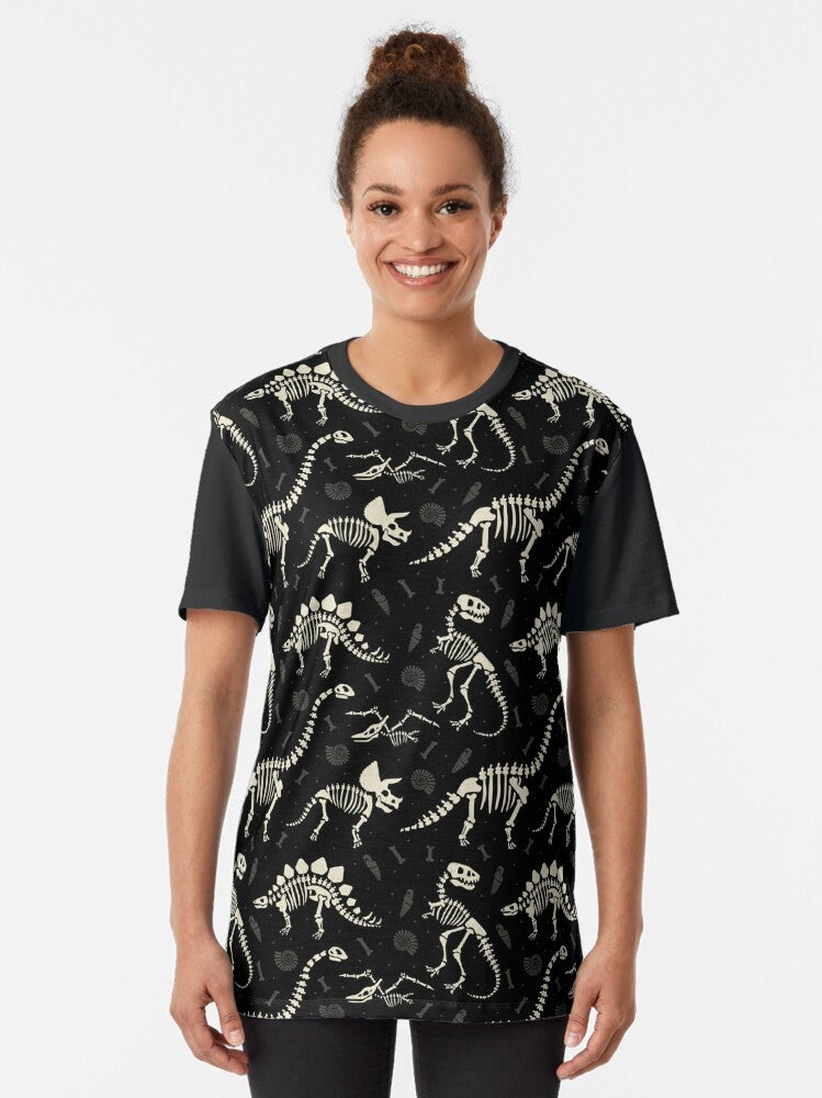 Black t-shirt with a graphic design of dinosaur fossils and bones. - Women