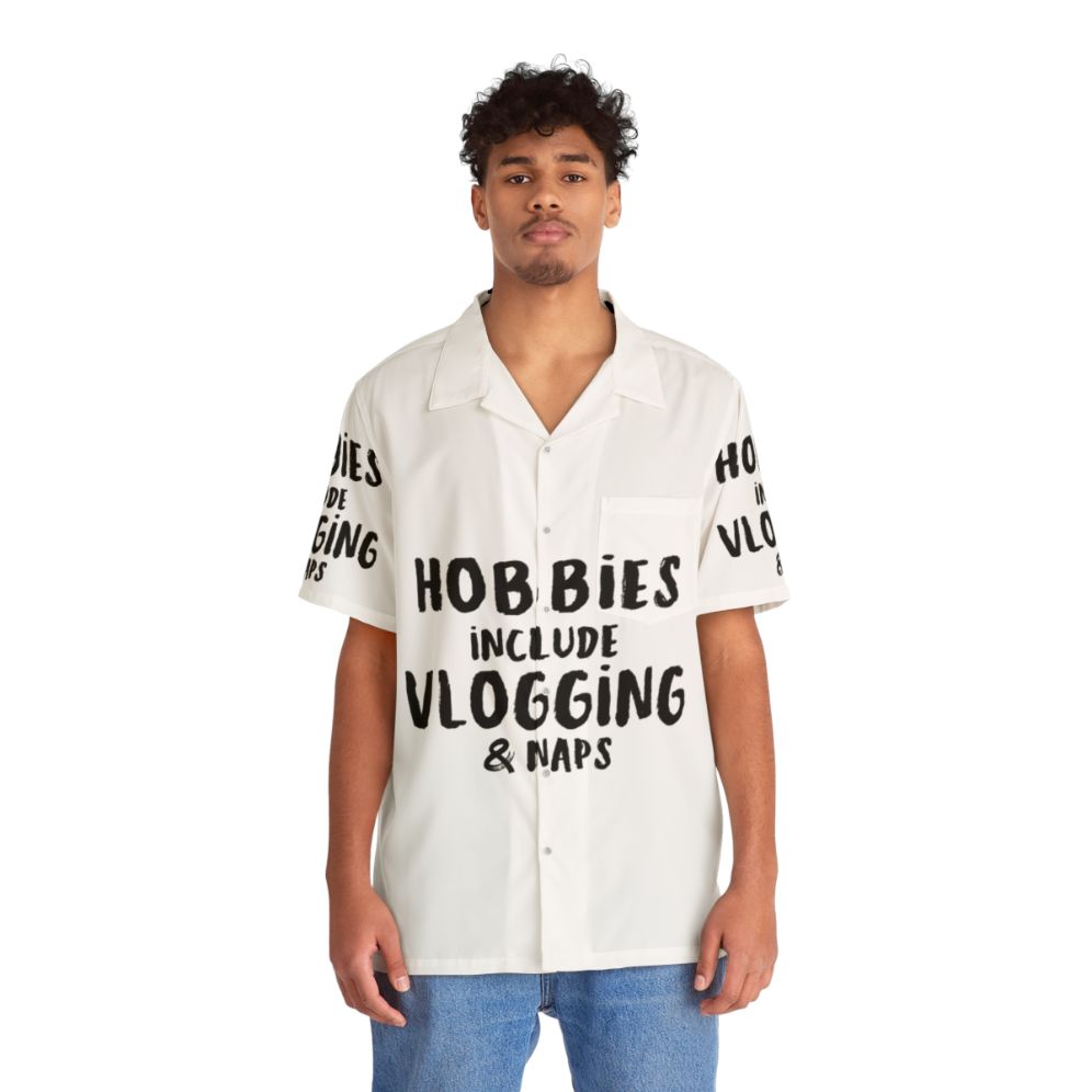 Man wearing a Hawaiian shirt with the text "Hobbies Include Vlogging And Napping" - People Front