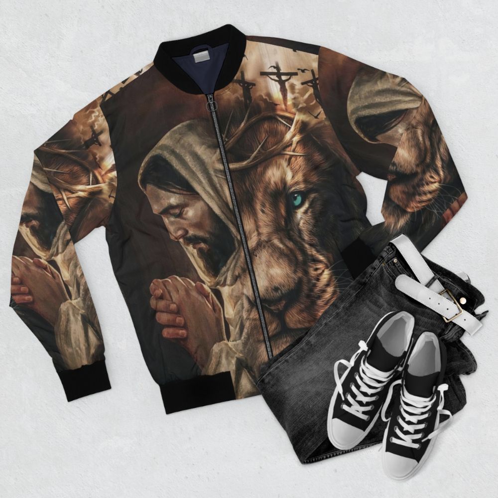 A stylish bomber jacket featuring the text "Jesus Pray and the Lion of Judah" - Flat lay