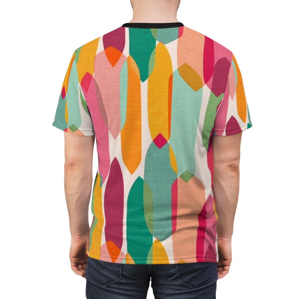 Model wearing a t-shirt featuring a vibrant mid century modern inspired abstract droplet pattern in a colorful kaleidoscope design - men back