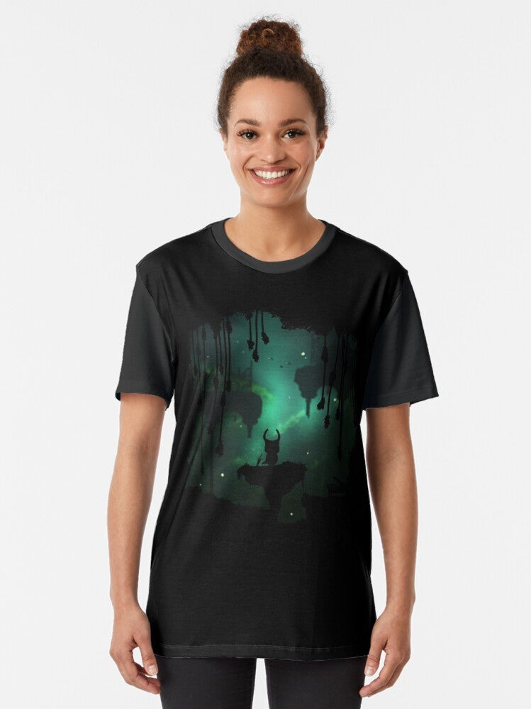 A graphic t-shirt featuring the Greenpath environment from the Hollow Knight game, with leafy elements, birds, and a peaceful nature theme. - Women