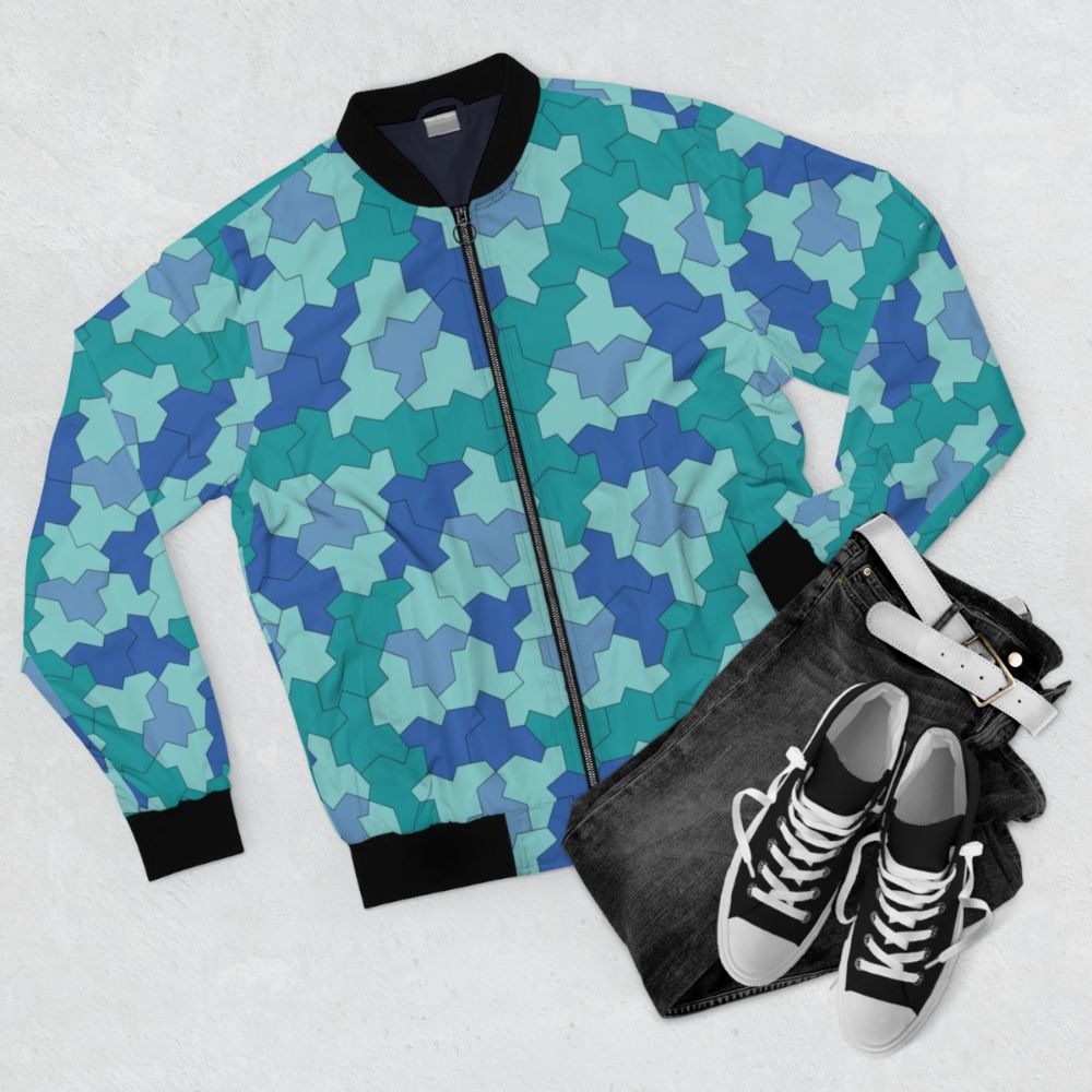 A blue and green bomber jacket featuring geometric Einstein shapes and aperiodic monotile patterns. - Flat lay