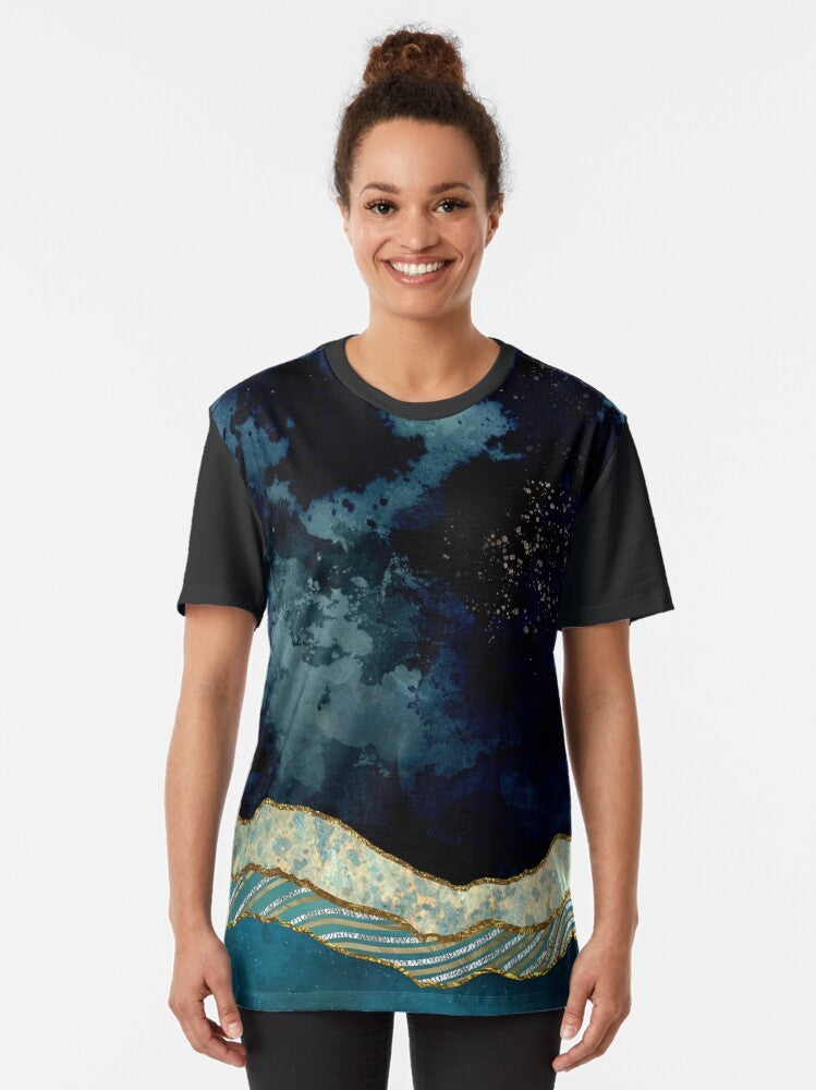 Indigo sky graphic t-shirt featuring a nature landscape design with mountains, stars, and a moon reflection on a lake. - Women