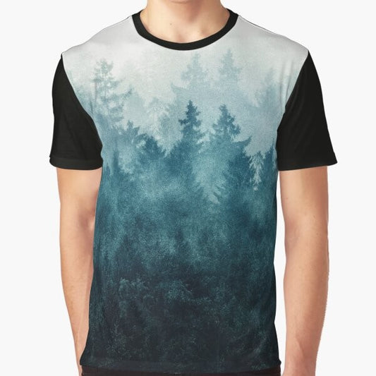 Graphic t-shirt design featuring a misty, foggy forest landscape with trees, mountains, and a blue-toned color palette