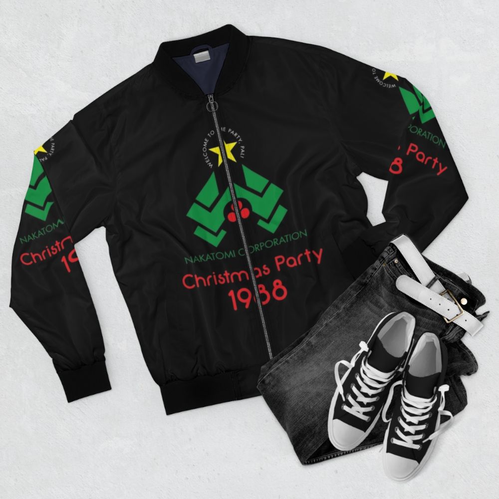 A stylish bomber jacket featuring the Die Hard movie logo, Christmas tree, and "Yippee ki yay" quote. - Flat lay