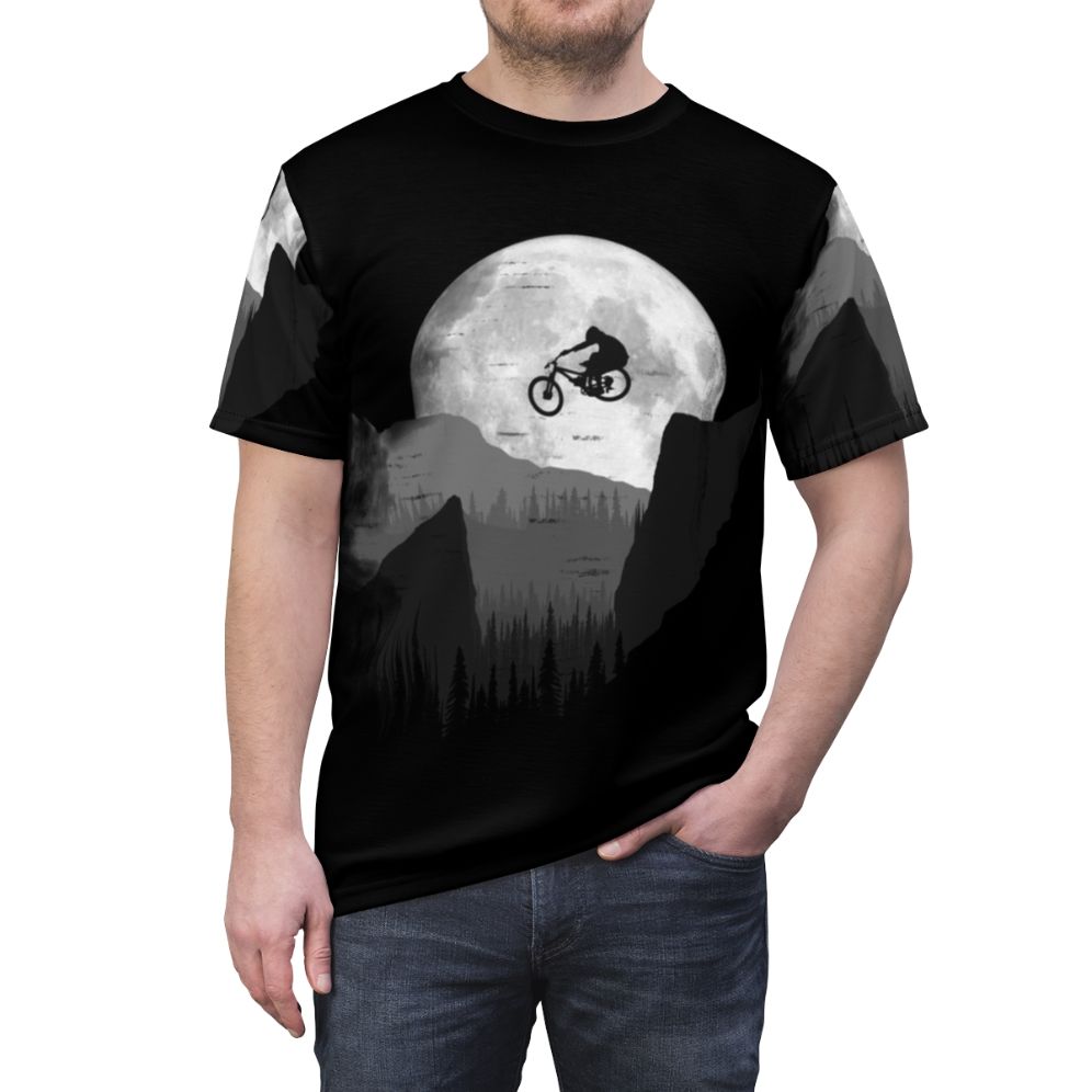 Graphic t-shirt design featuring a mountain bike silhouette jumping over the moon against a landscape background, perfect for outdoor enthusiasts and cyclists. - men front