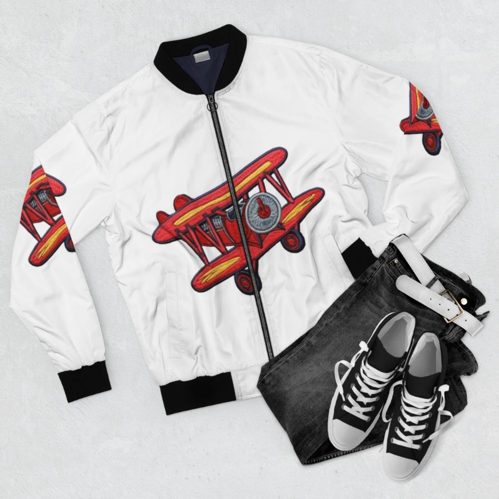 Embroidered bomber jacket with a crop duster airplane and pilot's patch design - Flat lay