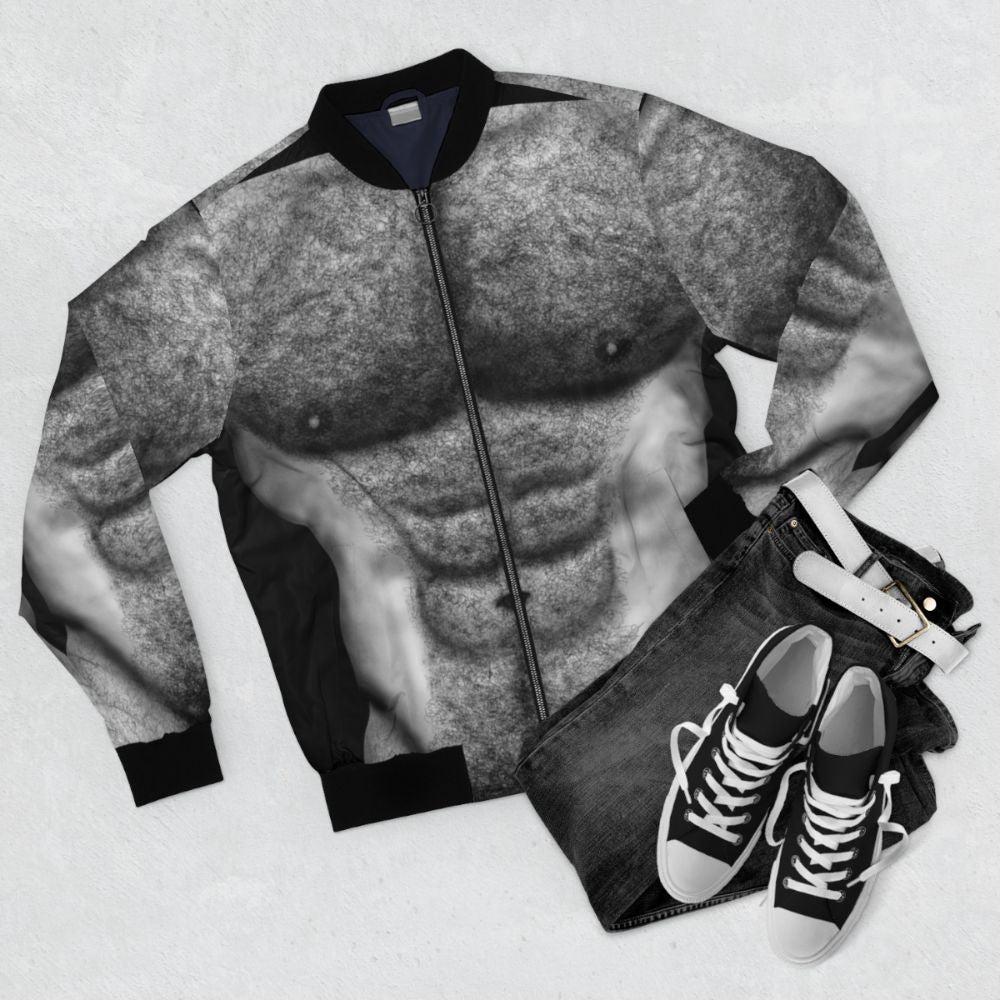 Bomber jacket featuring the hairy torso of a naked, muscular male figure in black and white. - Flat lay