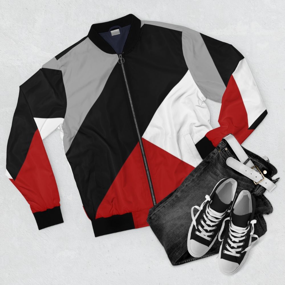 Black bomber jacket with diagonal stripes and triangular geometric pattern, a modern and minimalist design. - Flat lay