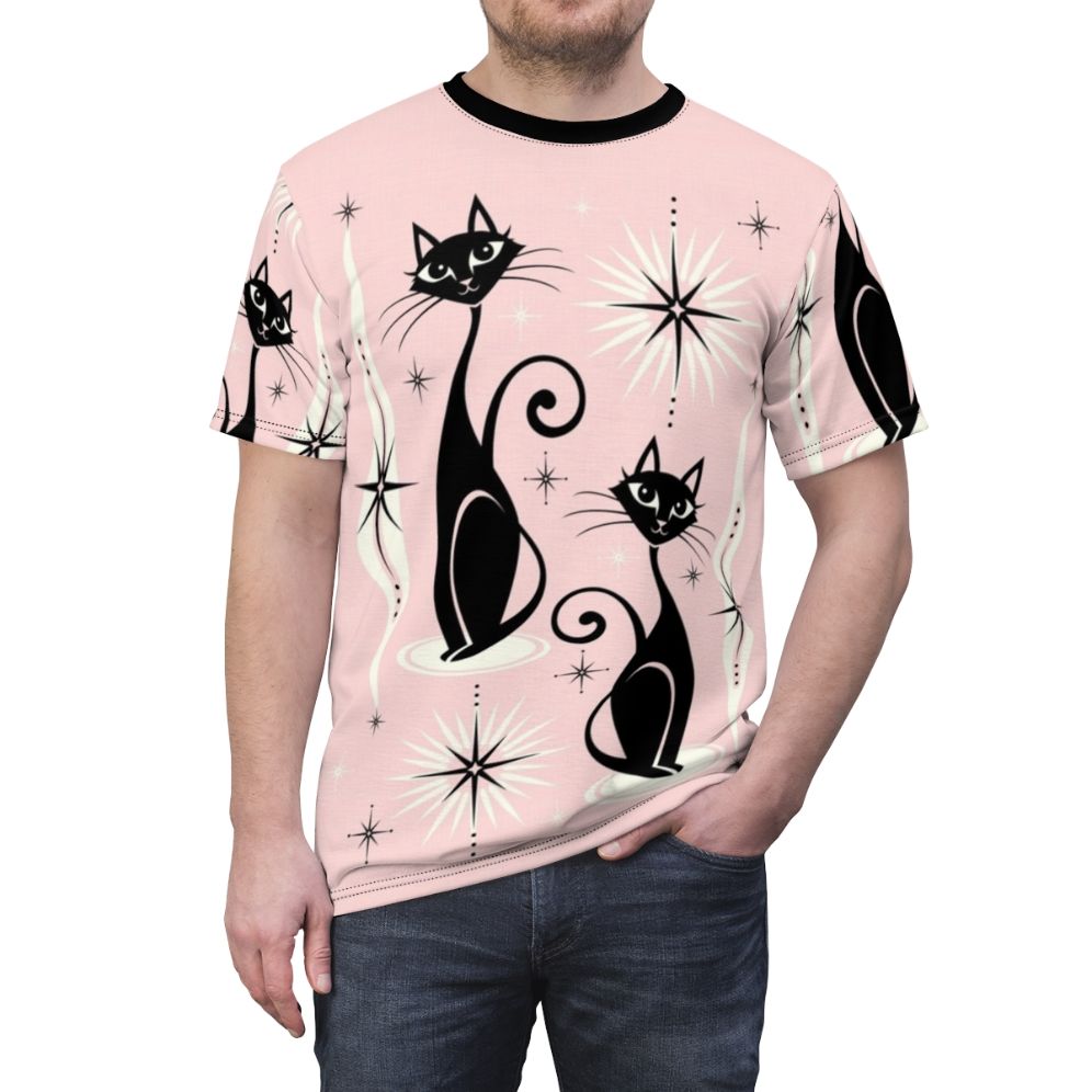 Model wearing a pink t-shirt with a mid-century modern atomic cat graphic design - men front