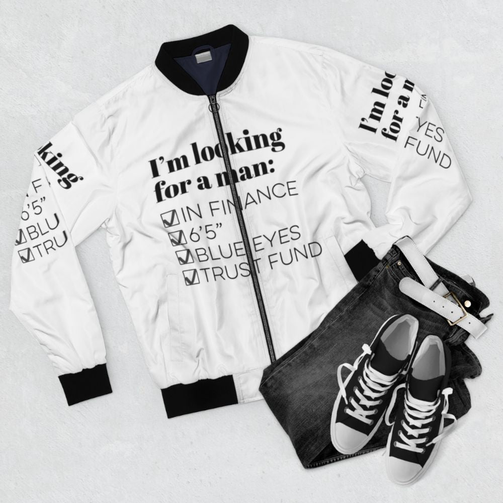 A blue bomber jacket with the text "I'm looking for a man in finance" on it, representing the TikTok song and humor for single people. - Flat lay