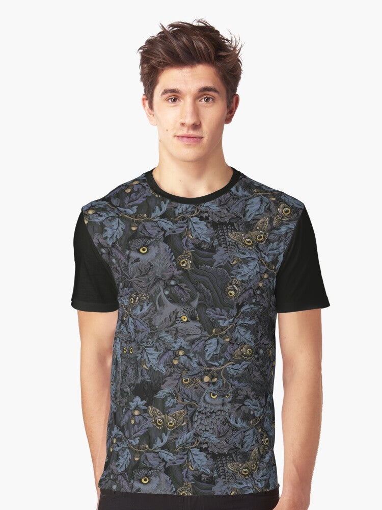 A graphic t-shirt featuring a camouflage pattern with owls, leaves, and moonlight imagery, capturing the beauty of nature's wilderness. - Men