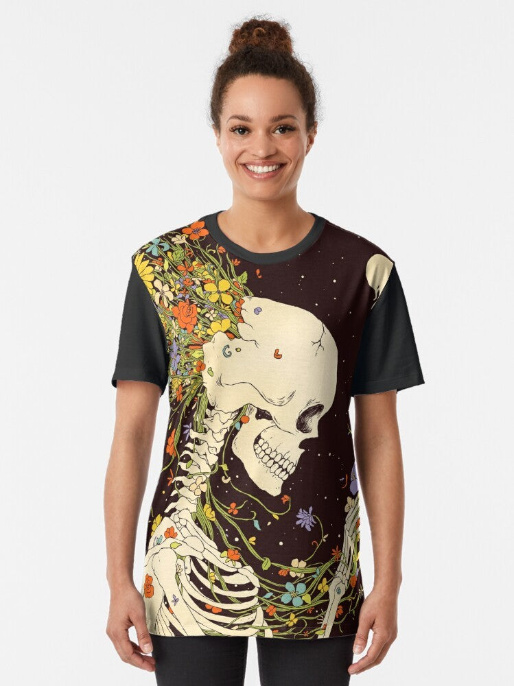 Surreal graphic t-shirt featuring a skull and skeleton design with floral and celestial elements, representing the beauty and impermanence of existence. - Women