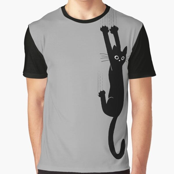 Graphic t-shirt featuring a black cat holding on with its claws and an expression of perseverance and humor