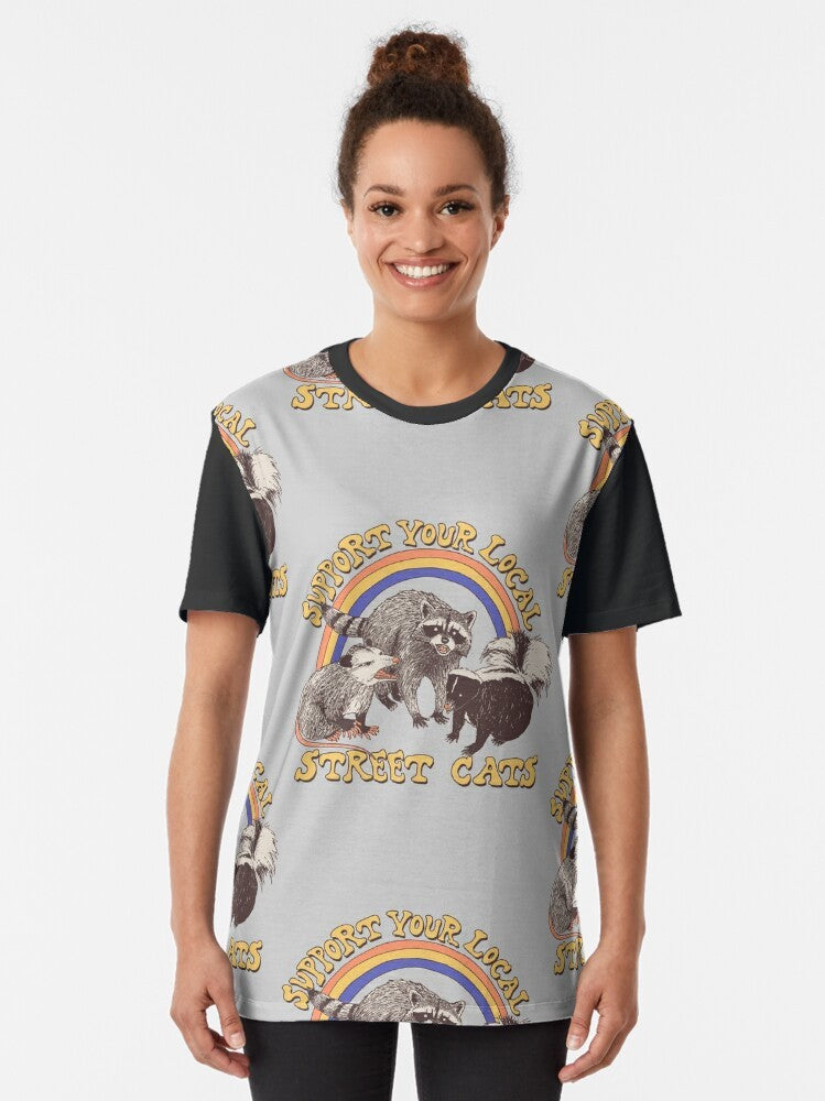 Retro-style graphic t-shirt featuring a design of various street cats, including cats, kittens, possums, skunks, and raccoons. - Women