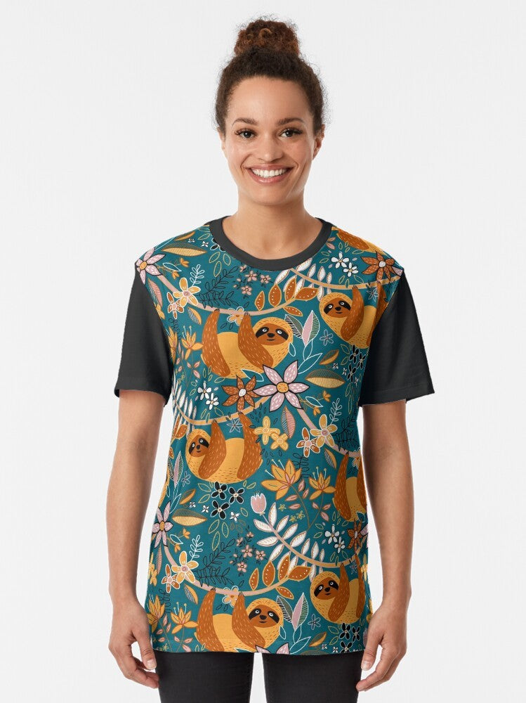 A happy, boho-style graphic t-shirt featuring a sloth surrounded by colorful floral patterns in teal, orange, brown, and blush. - Women