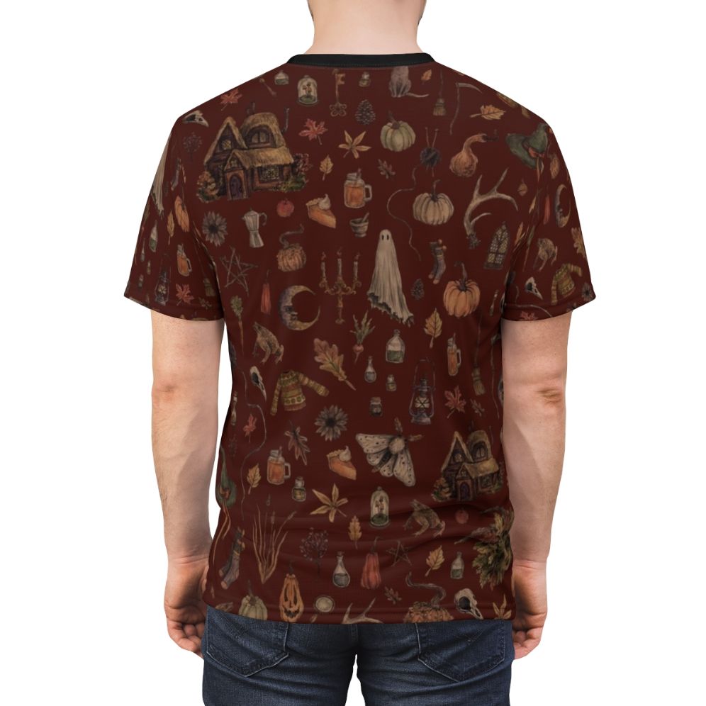 Model wearing a black t-shirt with an all-over print design featuring a crone or wise woman, black cats, ghosts, and other spooky, nature-inspired elements. - men back