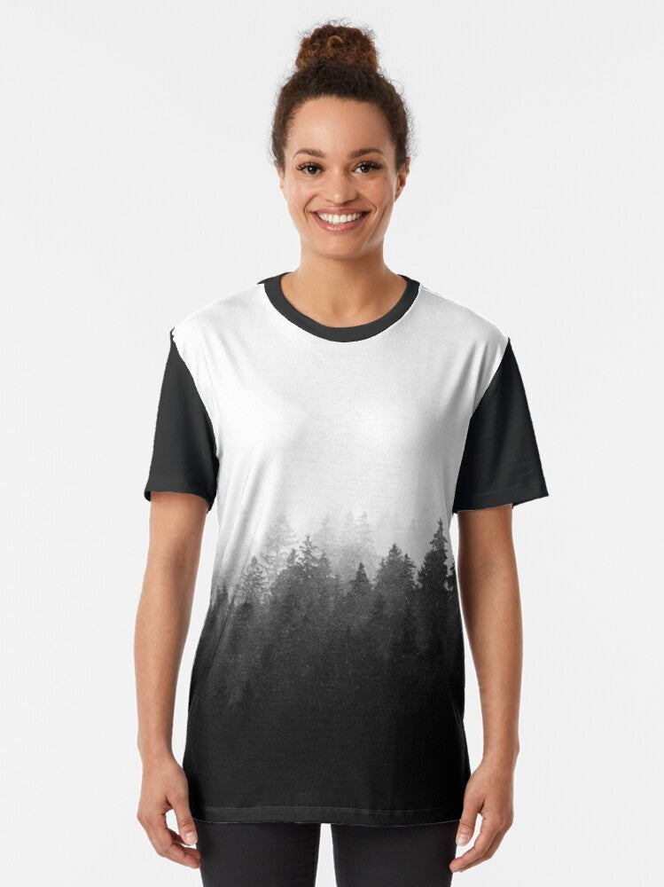 Graphic t-shirt featuring a wilderness landscape with trees, fog, and mountains - Women