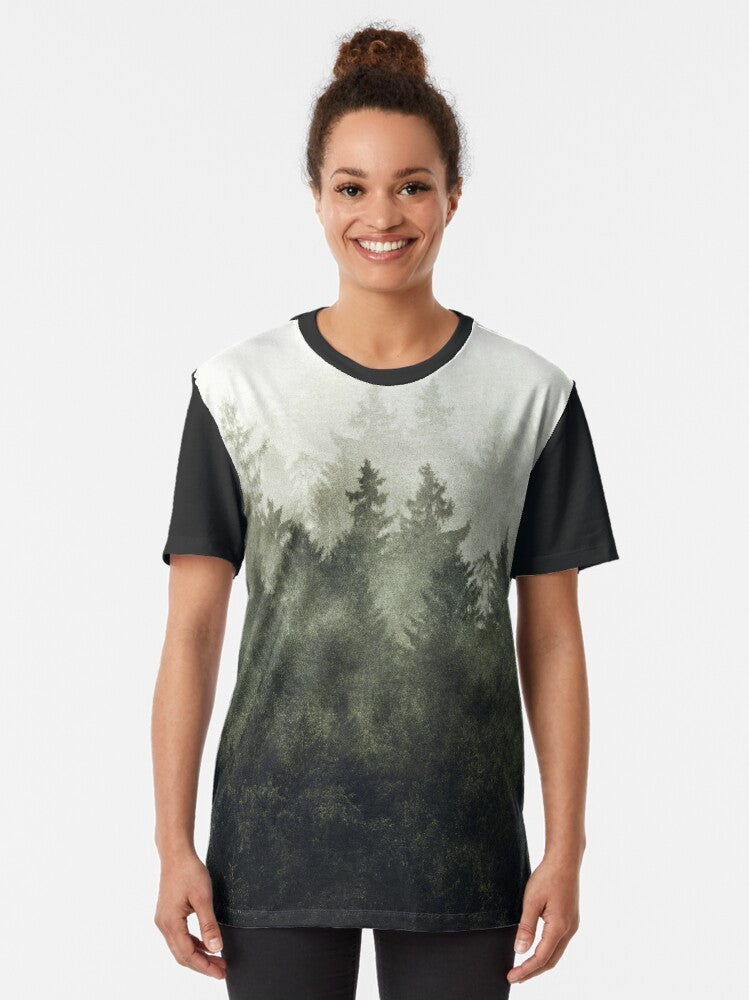 A green graphic t-shirt featuring a vintage-style illustration of a foggy, misty mountain landscape. - Women